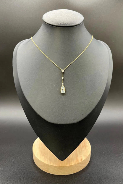 A pear shaped aquamarine and diamond drop pendant necklace in yellow gold