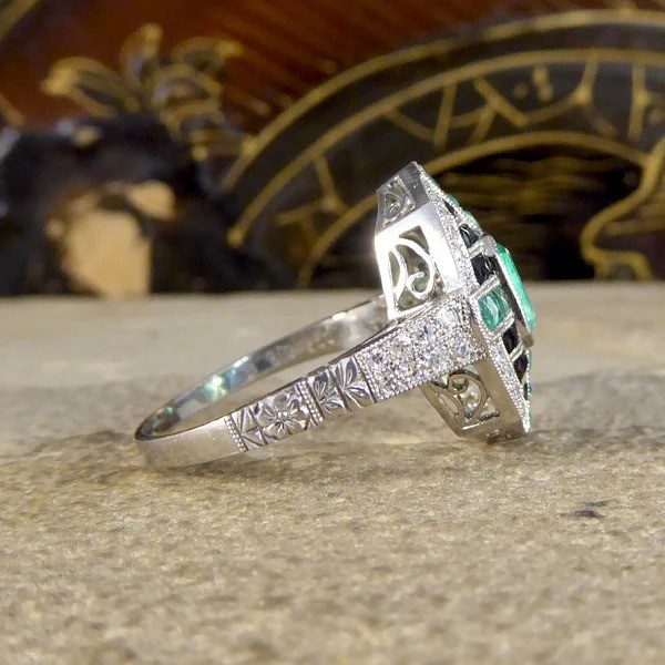 Emerald, onyx and diamond cluster ring in platinum.