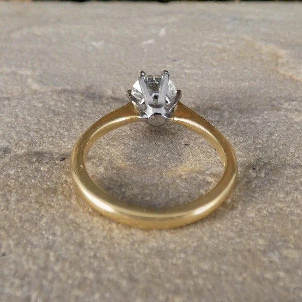Diamond solitaire ring in yellow and white gold.