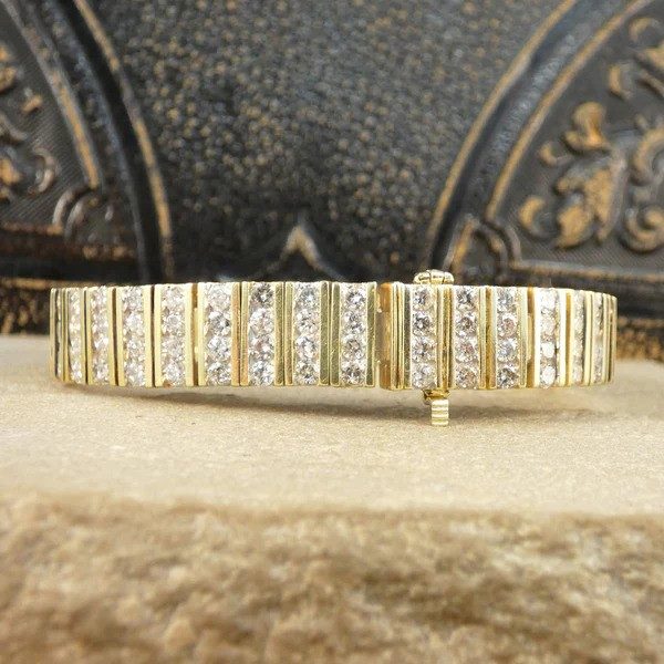 Diamond panel link bracelet in 14 carat yellow gold.