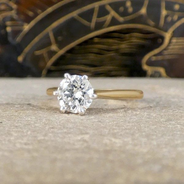 Diamond solitaire ring in yellow and white gold.