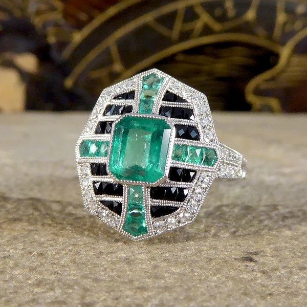 Emerald, onyx and diamond cluster ring in platinum.