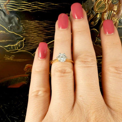 Diamond solitaire ring in yellow and white gold.