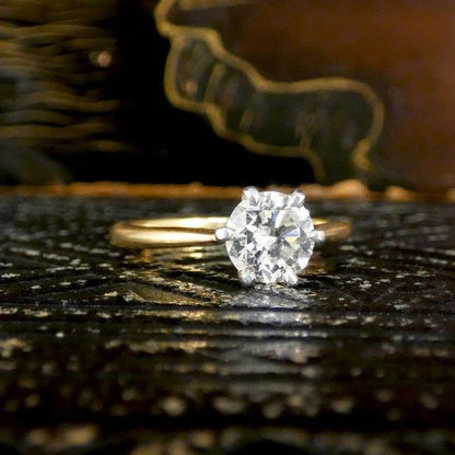 Diamond solitaire ring in yellow and white gold.