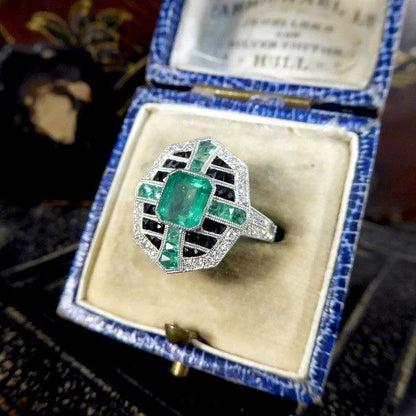 Emerald, onyx and diamond cluster ring in platinum.