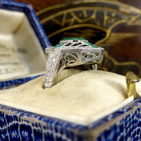 Emerald, onyx and diamond cluster ring in platinum.