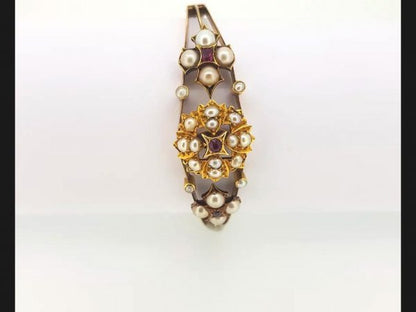 An Antique Edwardian Split Pearl and Ruby Bangle with central floral design and flanked by similar design, on detailed 15ct gold bangle