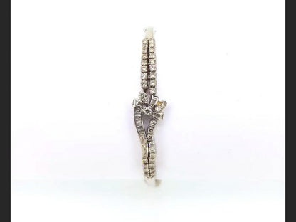 Diamond Bangle; Double row of round cut diamonds and baguette cut diamonds culminating in a delicate bow design, set in 18ct white gold
