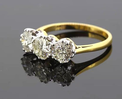 Three Stone Diamond Ring; A classic diamond trilogy ring featuring three round brilliant-cut diamonds totaling 2.06 carats, claw-set, 18ct yellow gold band.