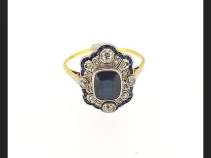 Vintage Sapphire and Diamond Ring; Central cushion cut sapphire encompassed by round cut diamonds and baguette cut sapphires. Reminiscent of the Art Deco style