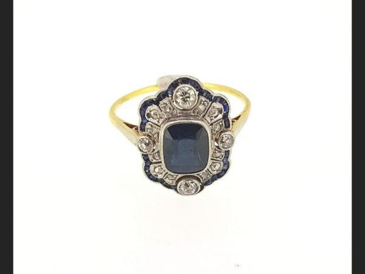 Vintage Sapphire and Diamond Ring; Central cushion cut sapphire encompassed by round cut diamonds and baguette cut sapphires. Reminiscent of the Art Deco style