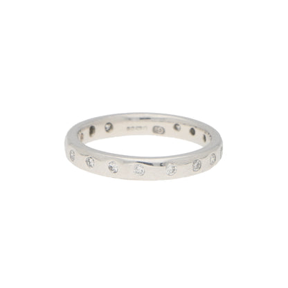 A white gold brilliant cut diamond eternity band, on a white background