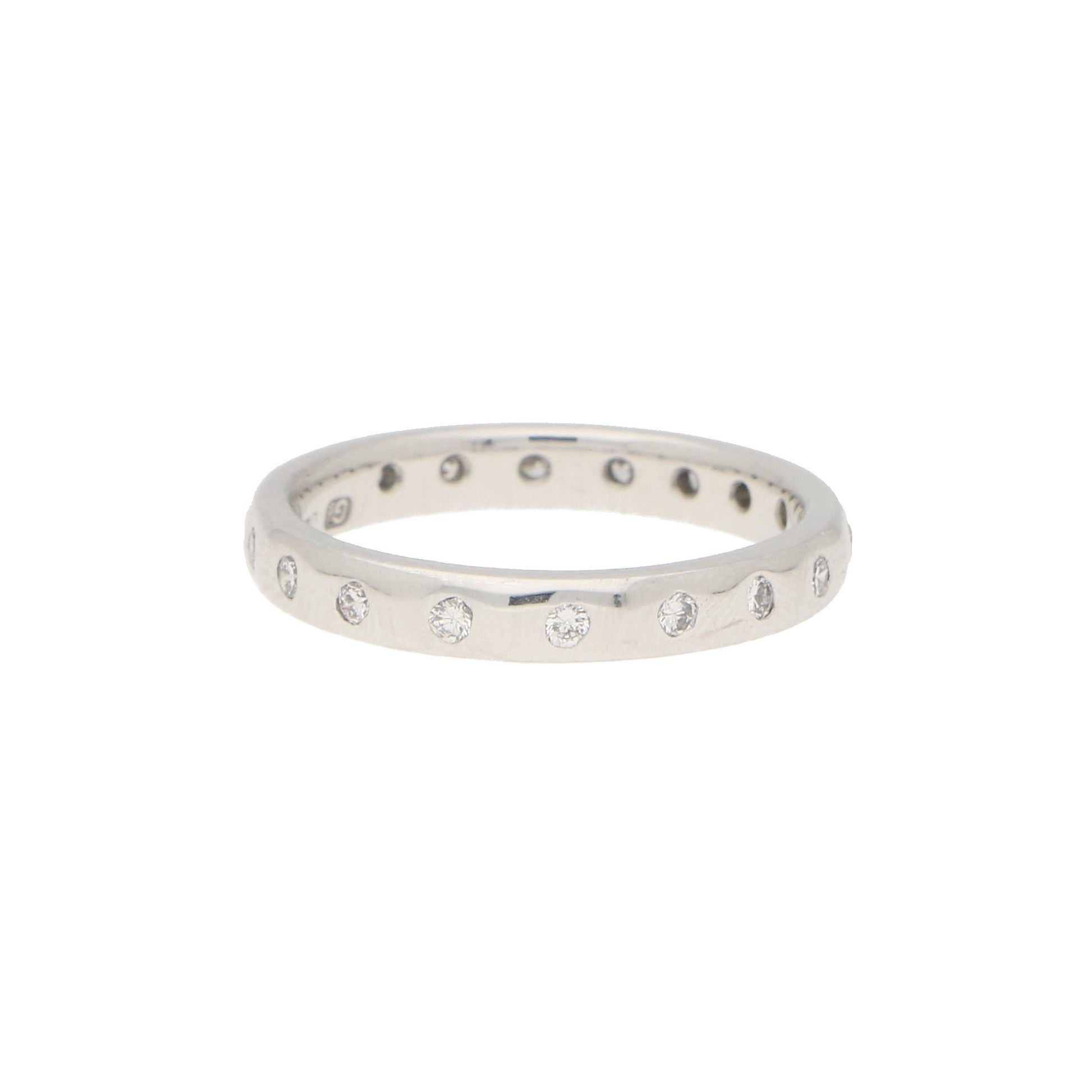 A white gold brilliant cut diamond eternity band, on a white background