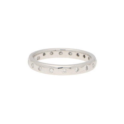 A white gold brilliant cut diamond eternity band, on a white background