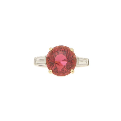 Pink Tourmaline and Diamond Engagement Ring; round faceted pink tourmaline four-claw set and flanked by two tapered baguette cut diamonds to the shoulders