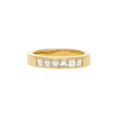 A yellow gold ring with six square diamonds, on a white background