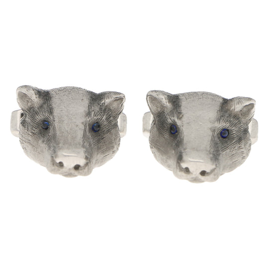 A pair of white gold badger head cufflinks with sapphire eyes, on a white background