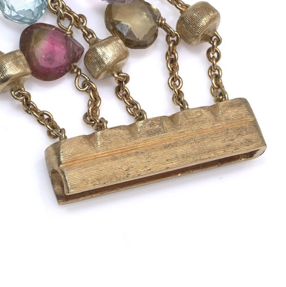A yellow gold five row multi-gemstone bracelet, showing a close-up of the clasp