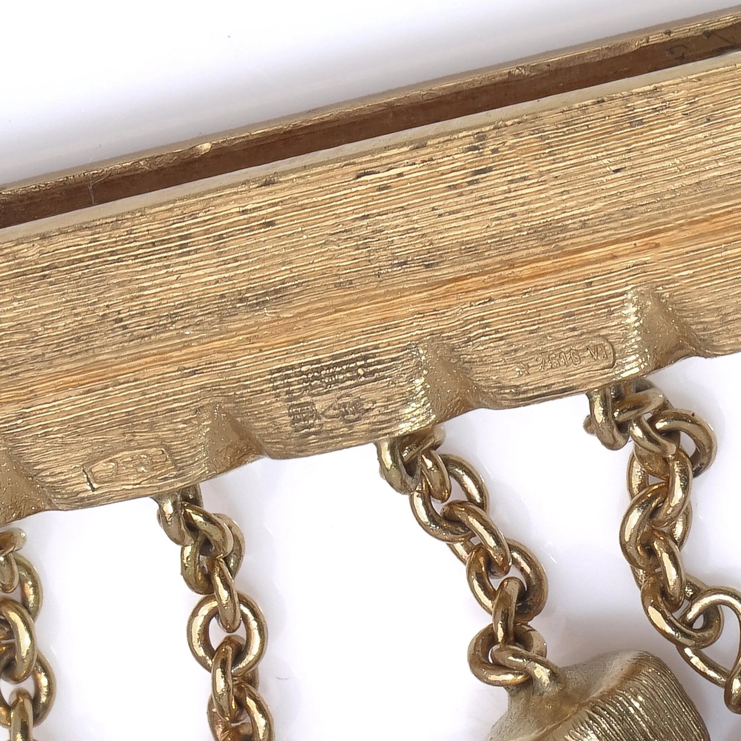 Close-up of stamps on a yellow gold bracelet clasp