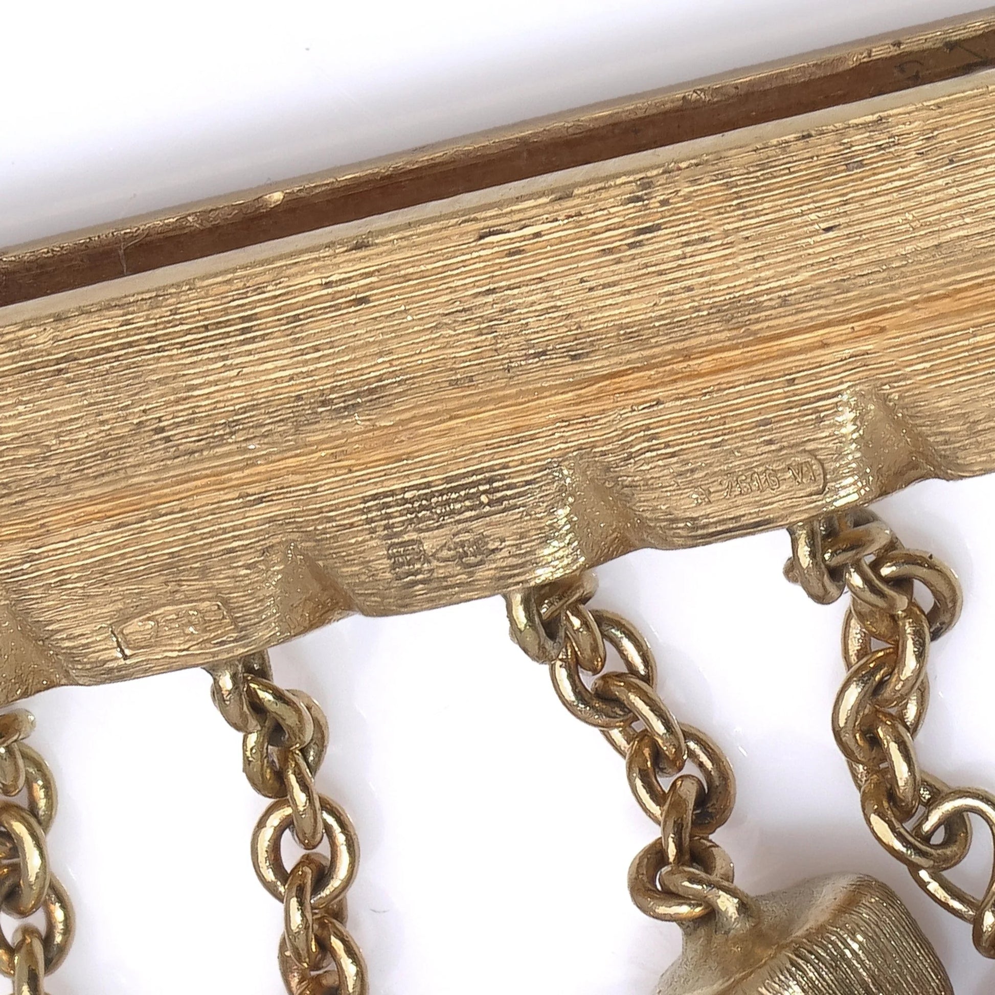 Close-up of stamps on a yellow gold bracelet clasp