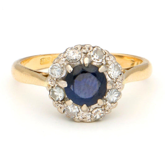 A sapphire and diamond circular cluster ring in yellow and white gold