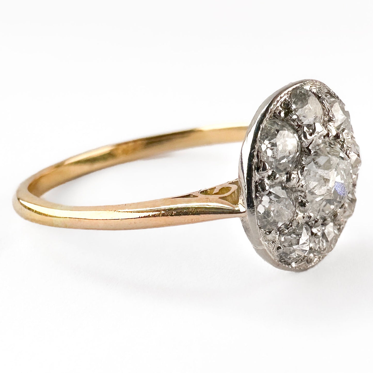 A circular cluster ring set with old cut diamonds in platinum and yellow gold