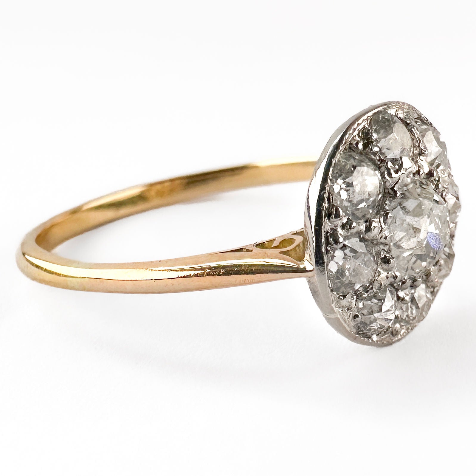 A circular cluster ring set with old cut diamonds in platinum and yellow gold