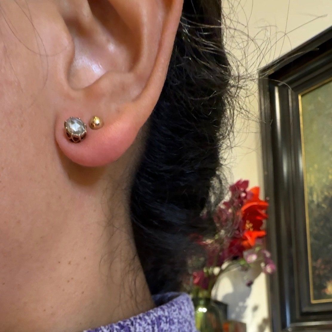 A yellow gold solitaire rose cut diamond stud earring, modelled in an ear