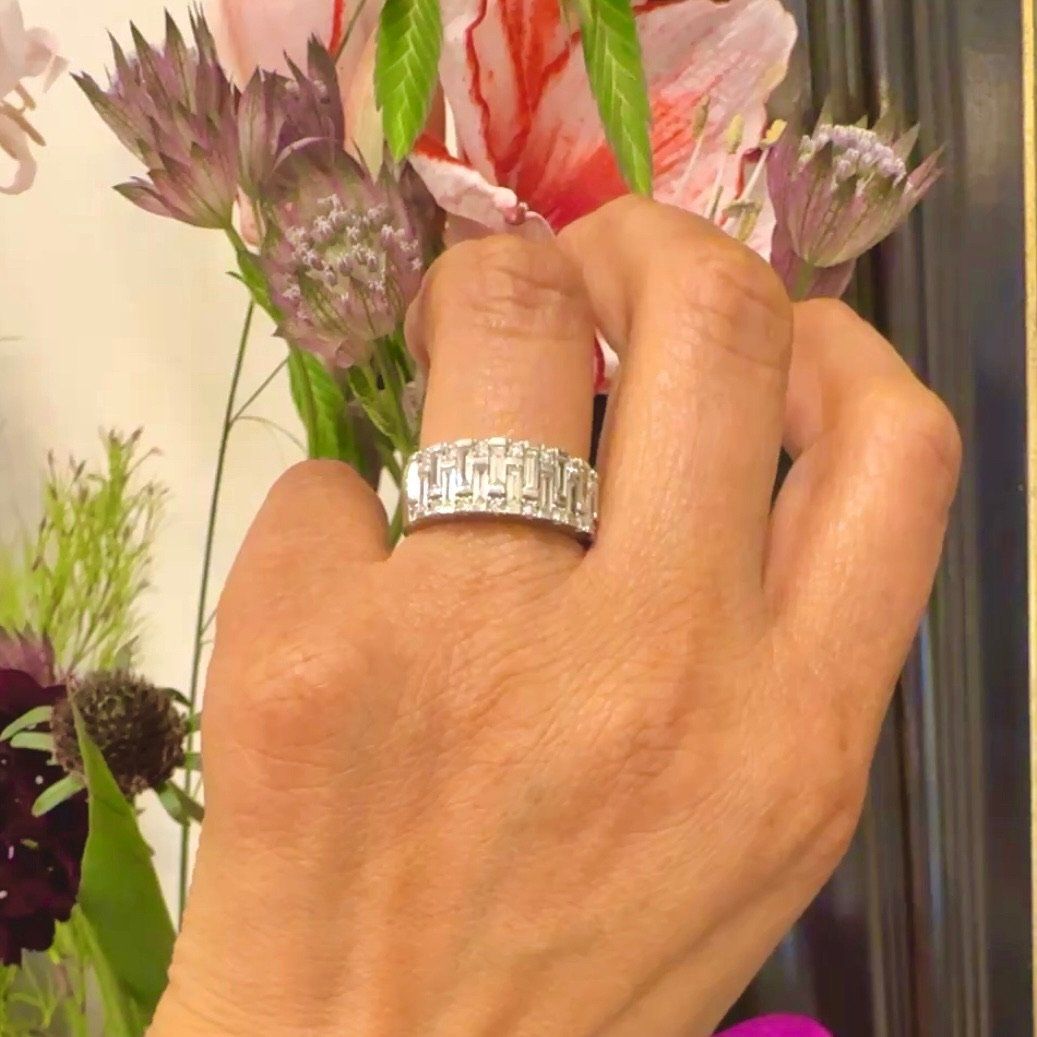 A baguette cut and brilliant cut diamond band ring in white gold, modelled on a hand