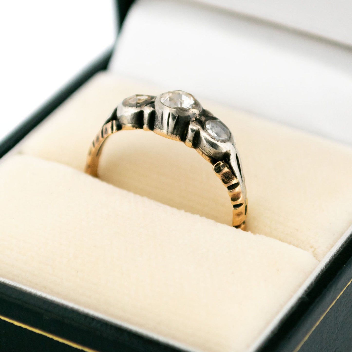 A yellow gold and silver rose cut diamond three stone ring, in a ring box