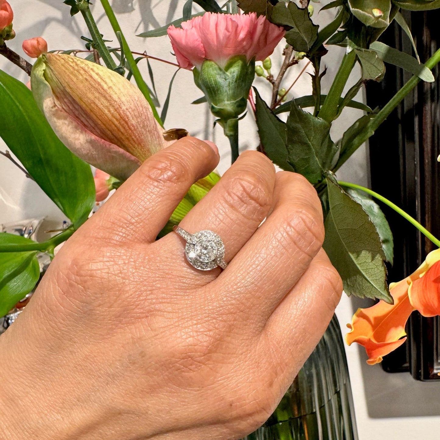 A halo target cluster ring set with diamonds in platinum, modelled on a hand