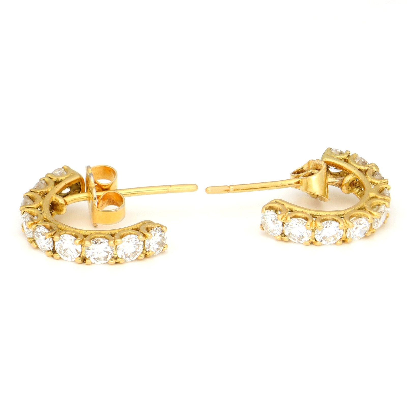 A pair of brilliant cut diamond half hoop earrings in yellow gold