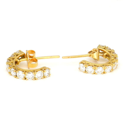 A pair of brilliant cut diamond half hoop earrings in yellow gold