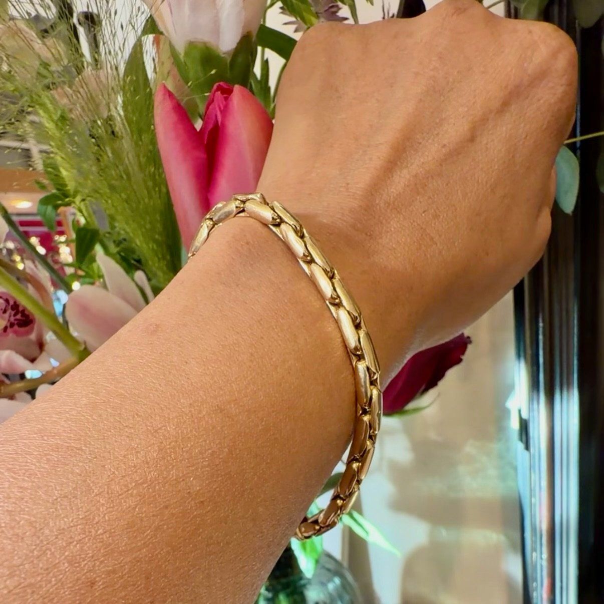 A yellow gold elongated box link bracelet, modelled on a wrist