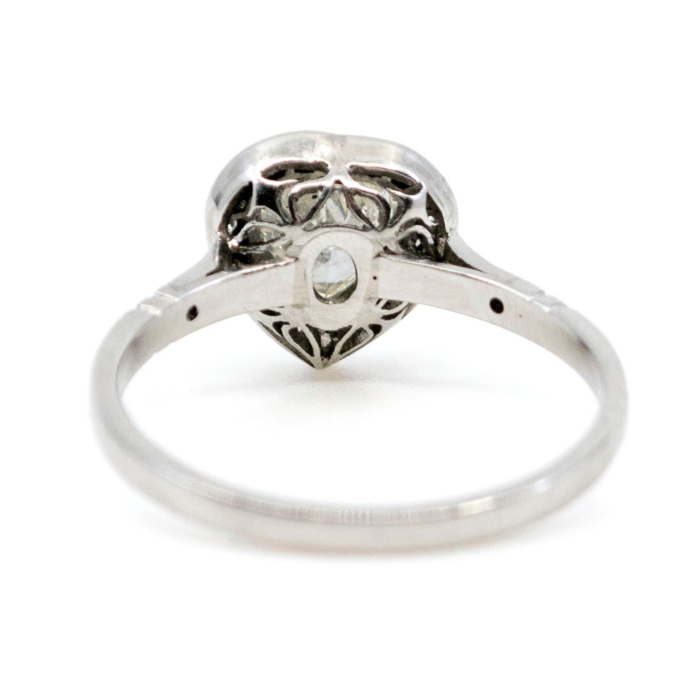 A heart shaped diamond cluster ring in platinum, with diamond shoulders