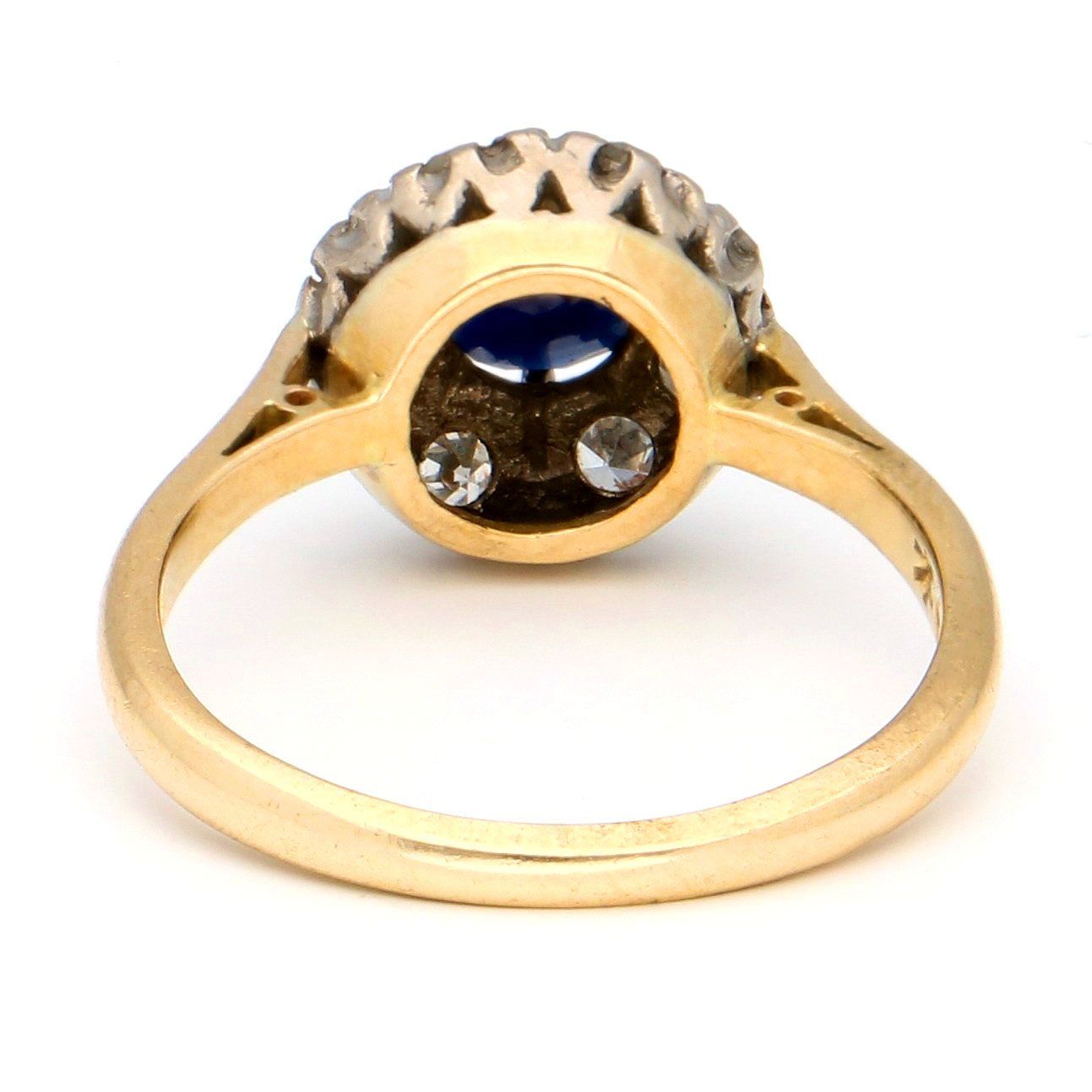A sapphire and diamond circular cluster ring in yellow and white gold