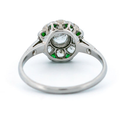 A diamond and emerald daisy cluster ring in platinum