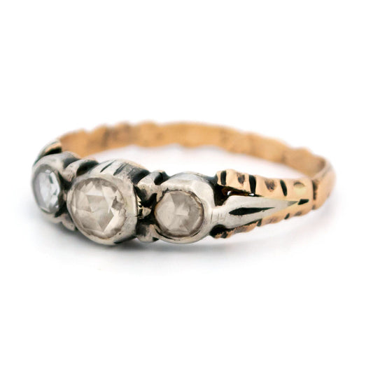 A yellow gold and silver rose cut diamond three stone ring