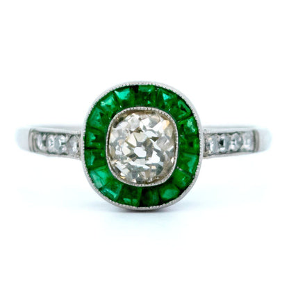 An emerald and diamond halo target cluster ring in platinum