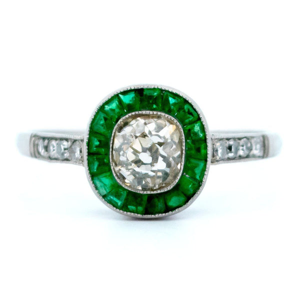 An emerald and diamond halo target cluster ring in platinum