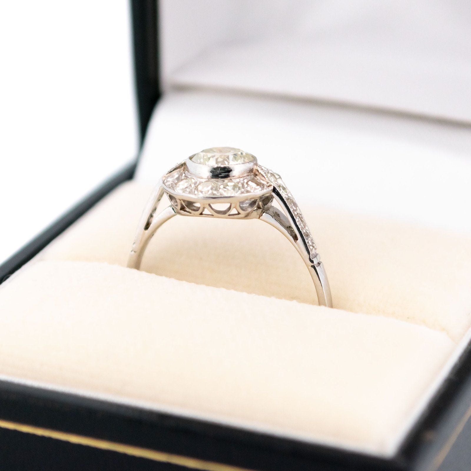 A halo target cluster ring set with diamonds in platinum, in a ring box