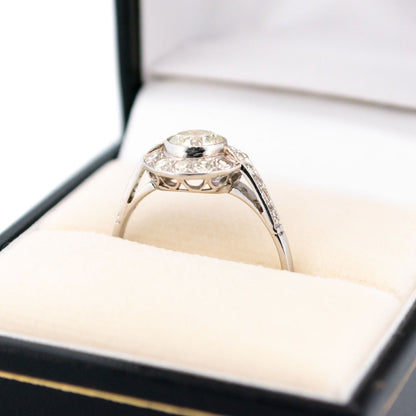 A halo target cluster ring set with diamonds in platinum, in a ring box