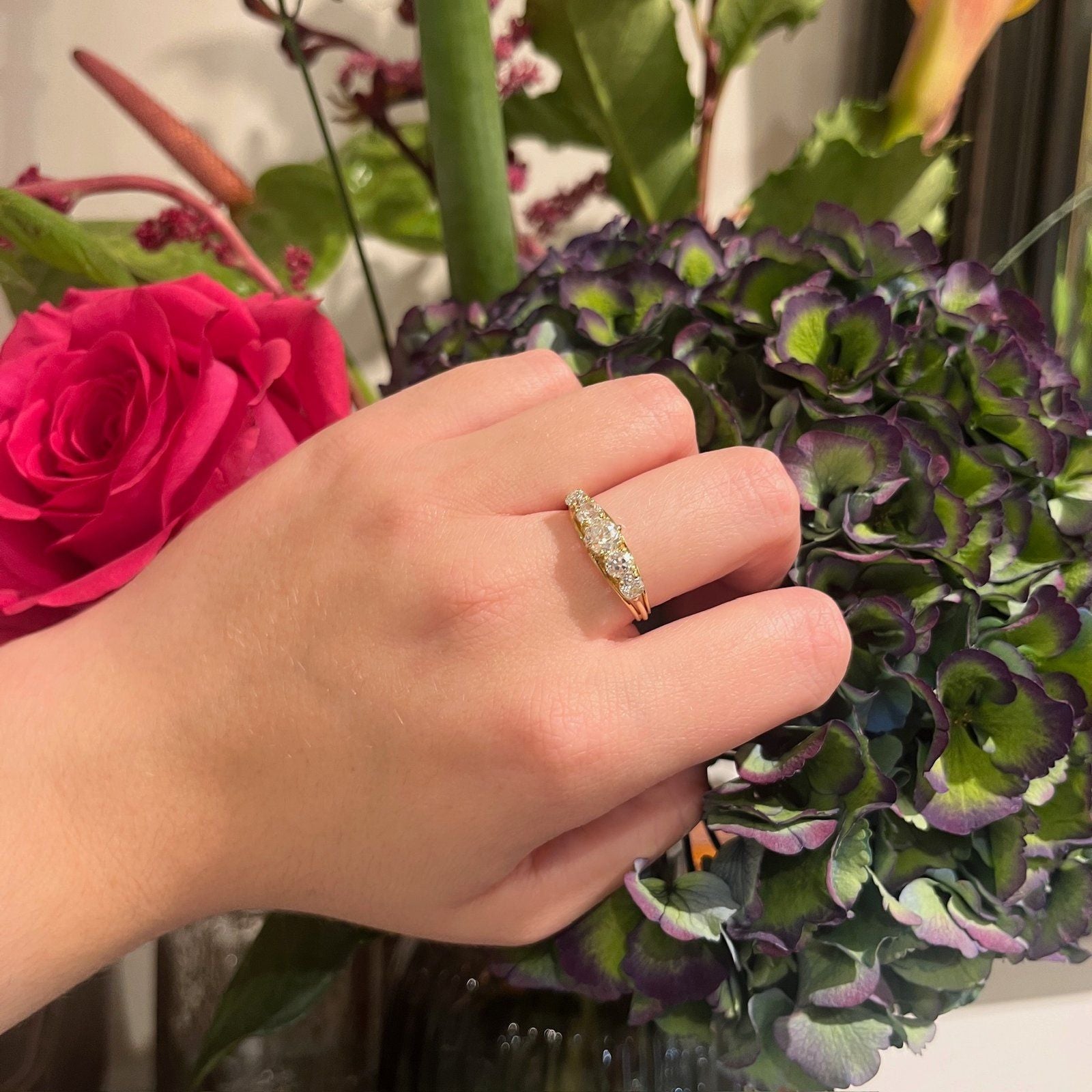 A graduated five stone diamond ring in yellow gold, modelled on a hand