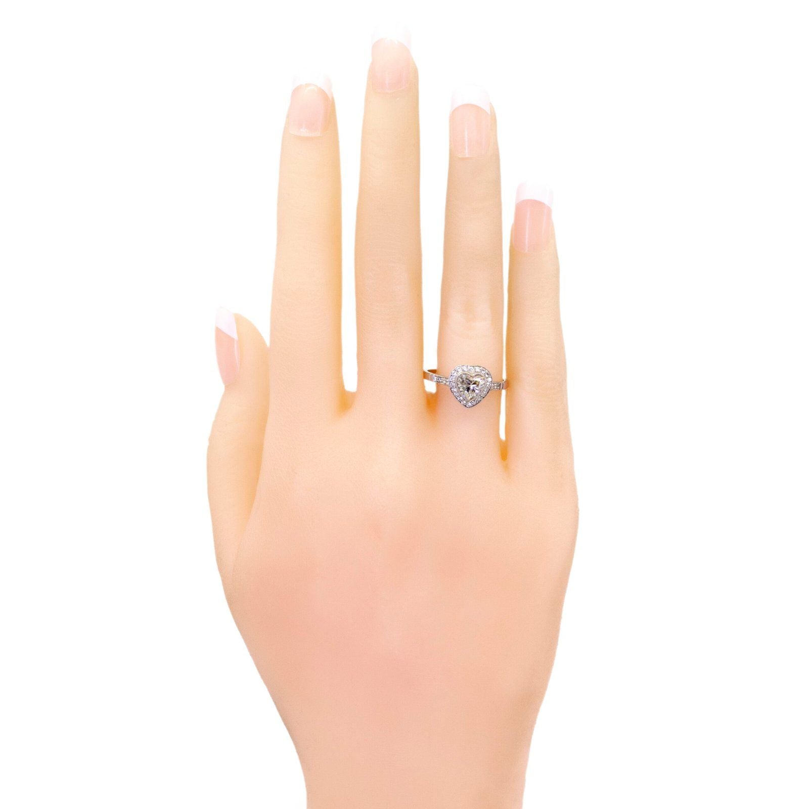 A heart shaped diamond cluster ring in platinum, with diamond shoulders, modelled on a hand
