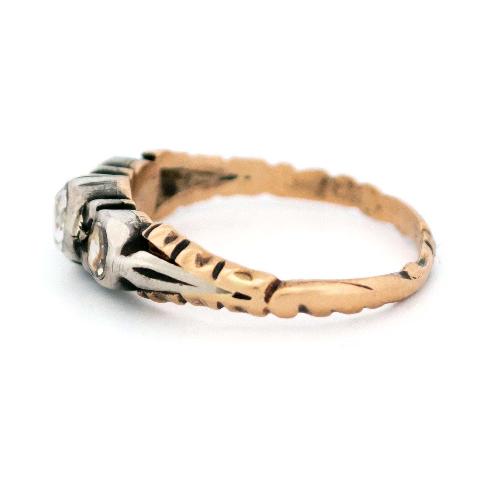 A yellow gold and silver rose cut diamond three stone ring