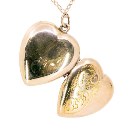 A yellow gold heart shaped locket, with a chain