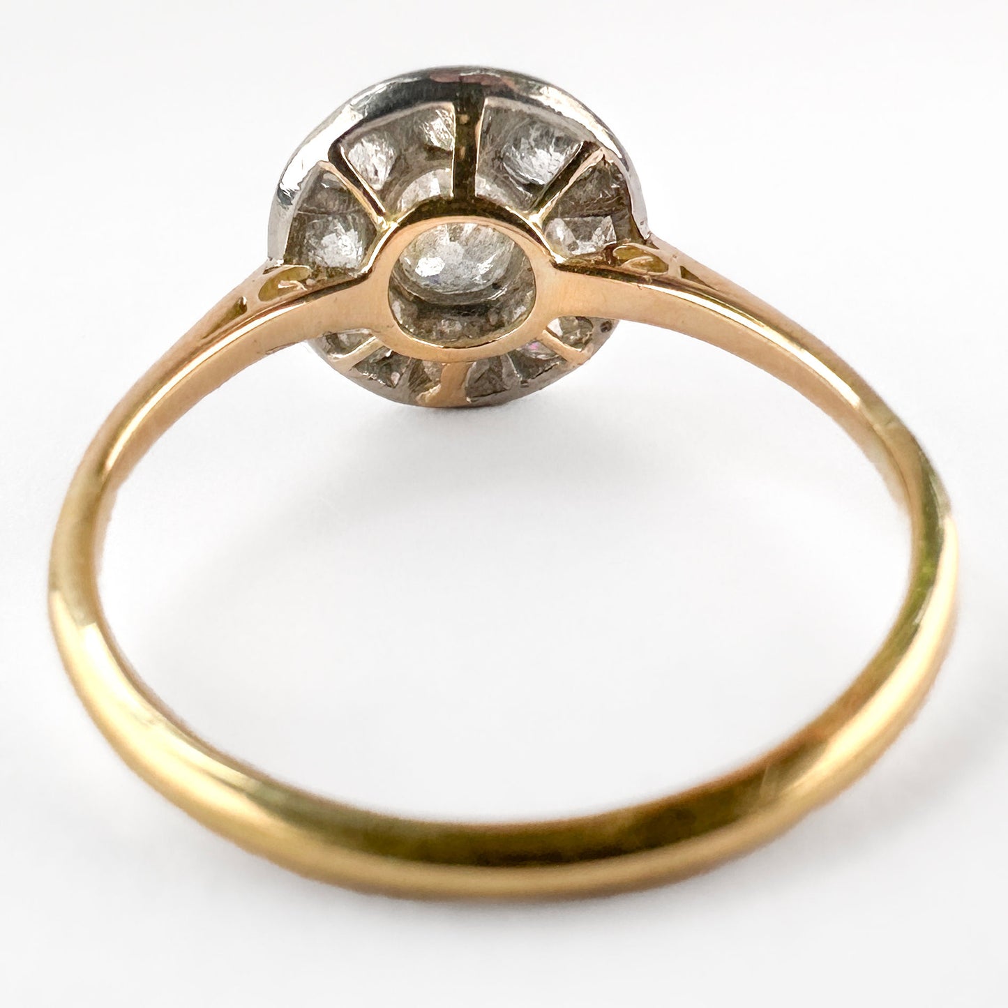 A circular cluster ring set with old cut diamonds in platinum and yellow gold