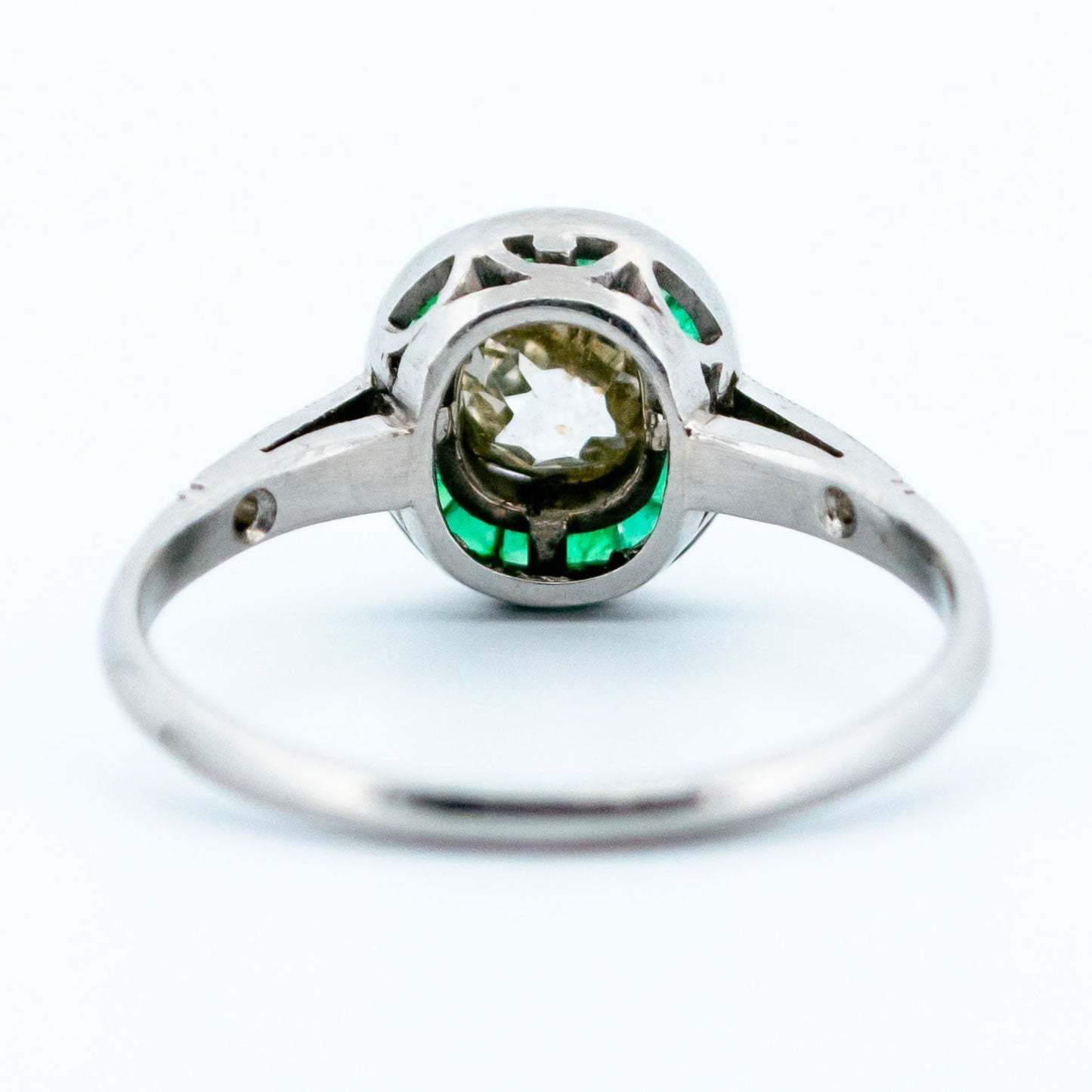 An emerald and diamond halo target cluster ring in platinum