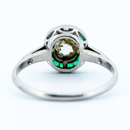 An emerald and diamond halo target cluster ring in platinum