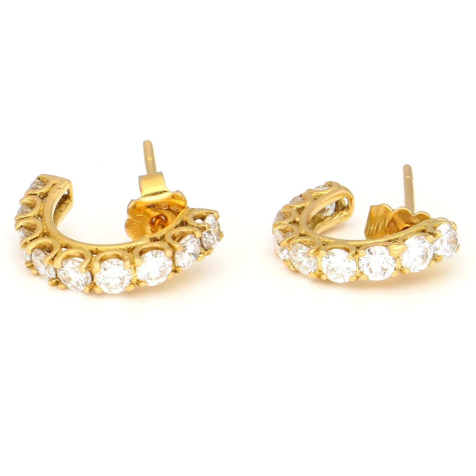 A pair of brilliant cut diamond half hoop earrings in yellow gold